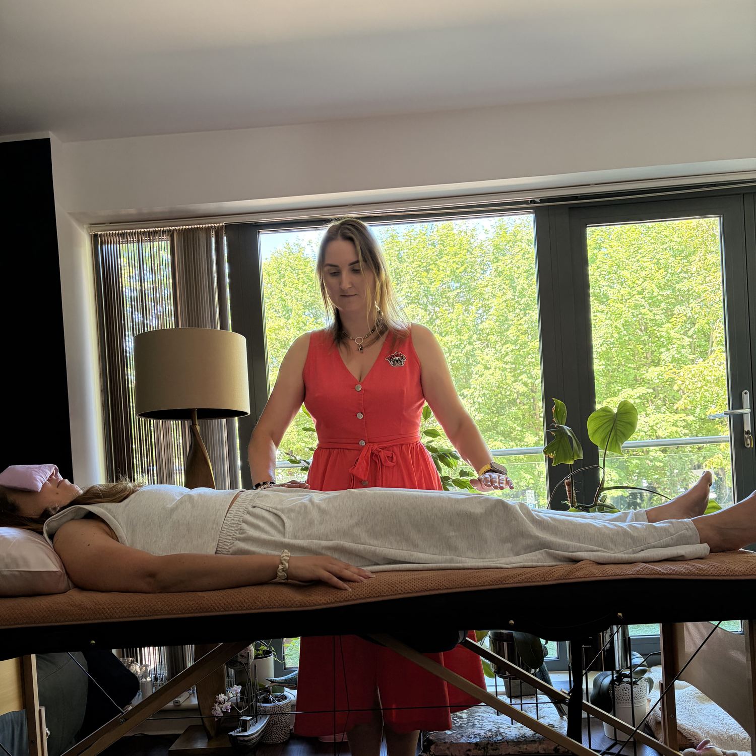 Anna giving a hands-on Reiki session to a client resting on a treatment table
